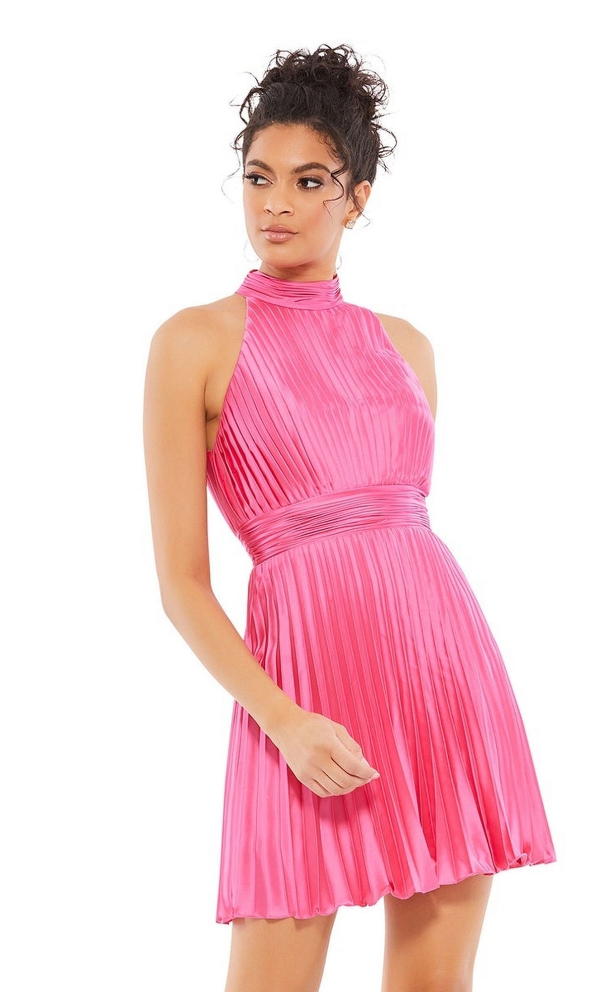 Woman in a sleeveless, high-neck pink satin Short Pleated Hoco Dress (Mac Duggal 26645), standing and looking to the side—a chic choice for homecoming or cocktails.